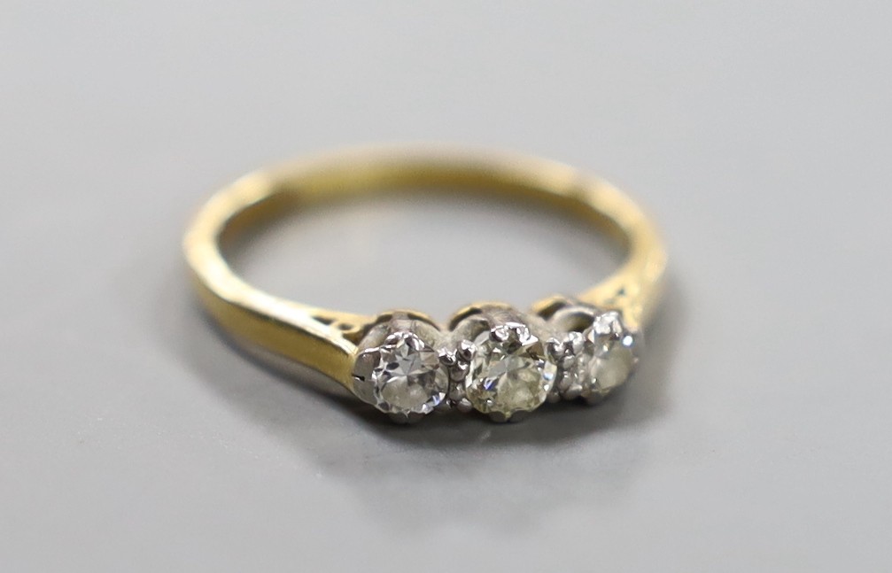 An 18ct, plat and three stone diamond set ring, size J, gross weight 2 grams.